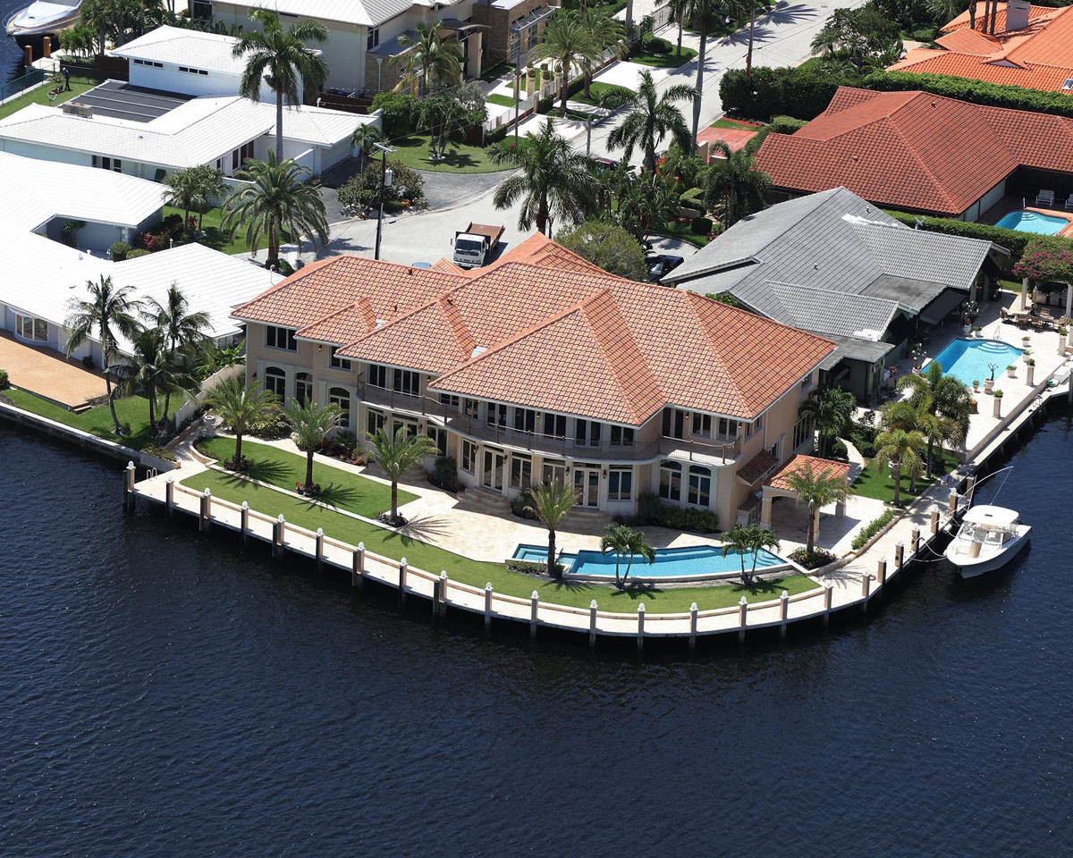 large homes near body of water with various colored roofing