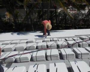 men putting down tiles for a roof